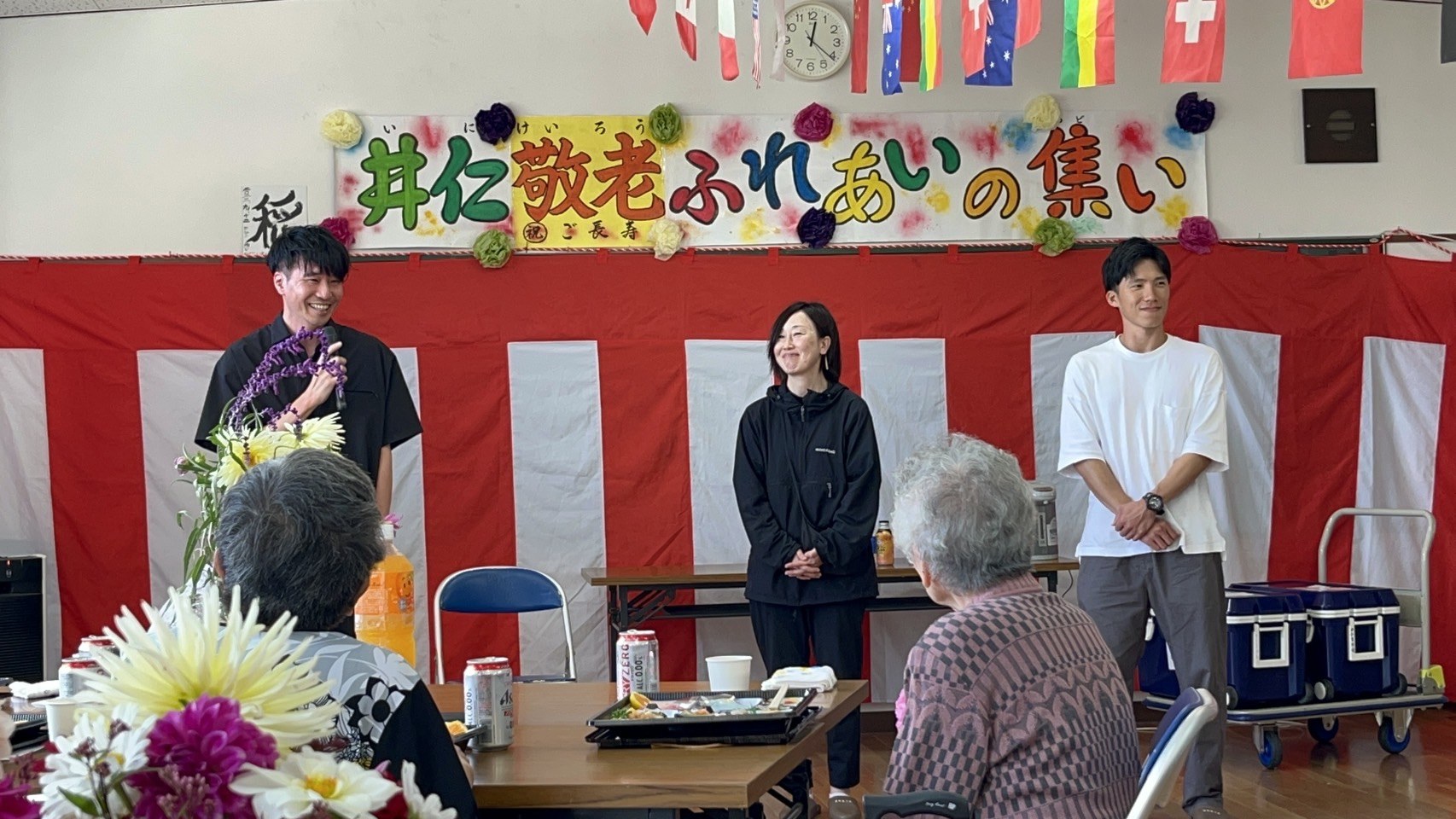 井仁敬老ふれあいの集いで、参加者が前に立ち交流する様子