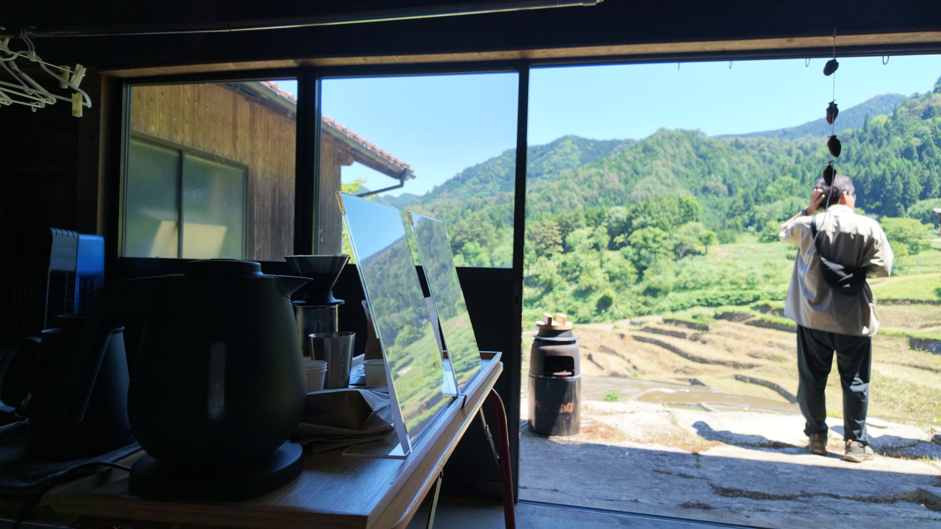 室内のコーヒー道具と、開いた戸の向こうに広がる棚田