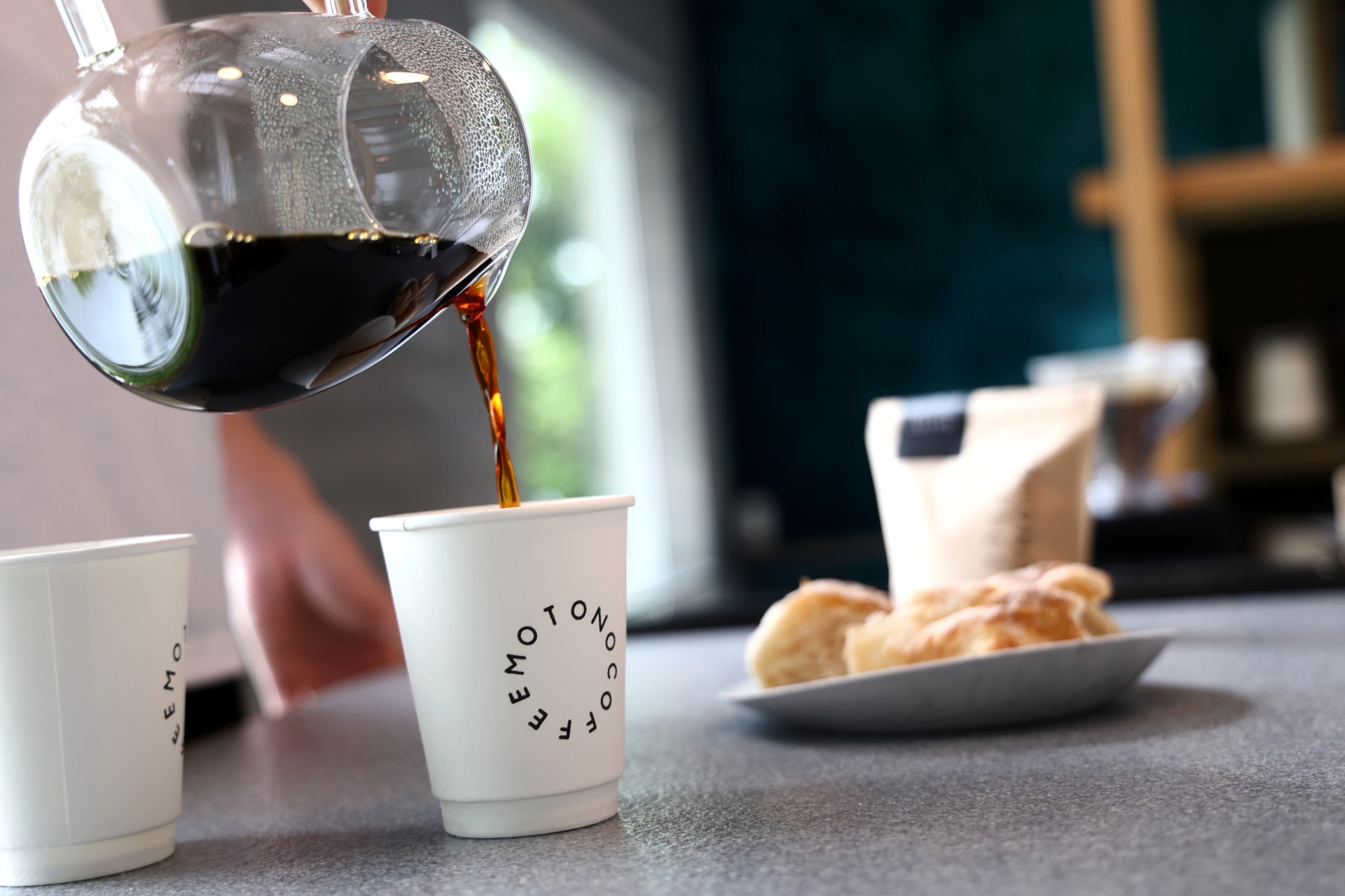MOTONO COFFEEのロゴ入りカップへコーヒーを注ぐ様子